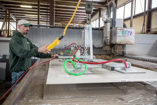 employee cutting stone for countertop in Saratoga factory